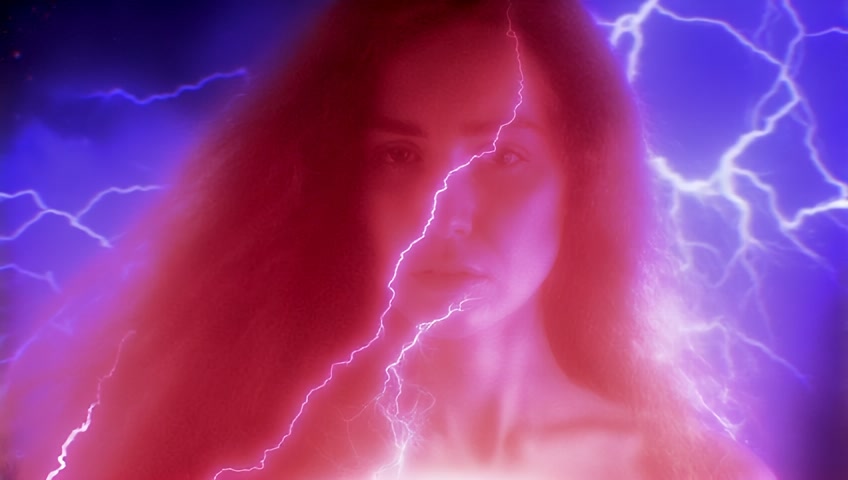 Real life footage traveling at extreme high-velocity close-up full body view  A determined attractive mysterious enigmatic woman with flowing long  red hair dances amidst swirling electricity, her moist skin reflecting intense light as it cascades across her toned, mezmerizing body The low-angle close-up captures hyper-realistic details—muscle tension in her limbs, individual strands of hair illuminated by a electirc glow, and power rippling through shallow depth-of-field framing, while dynamic camera movement mirrors her controlled yet primal motions against the raging power, weightless, flying through cosmic intergalctic space. Bright.. Immersive. Superfine. Ultrafine. Coherent Motion.  Perfect Anatomy.