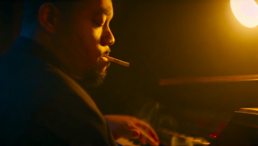 1920s jazz club, low golden light, swirling cigarette smoke. A close-up of Pine Top Smith, eyes closed, completely lost in the rhythm. His fingers move like a blur over the piano keys, the music visually radiates around him in waves of golden and deep blue hues. Expressive brushwork, cinematic framing, artistic depth.