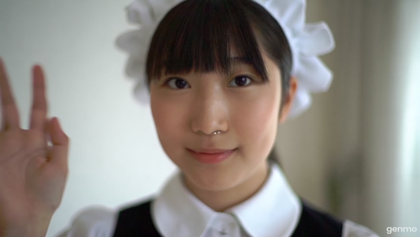 ein japanisches mädchen in einem maid outfit die in die kamera schaut und ihre rechte hand ganz schnell schüttelt