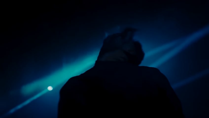 A cinematic scene. A man (Youssef) suddenly stops running in a dark, mysterious environment. The camera slowly circles around him. He lifts his head confidently. On the screen appears the bold text:

"If you're scared… go back.
If you're stuck… move.
But me… I'm moving forward."

The music is very soft and ambient at first, then suddenly drops with a heavy cinematic boom and red flash. The background is moody and intense.
Style: dramatic lighting, realistic, 16:9 aspect ratio, slow motion effect.