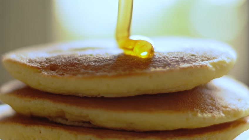 honey is pouring on top of pancakes