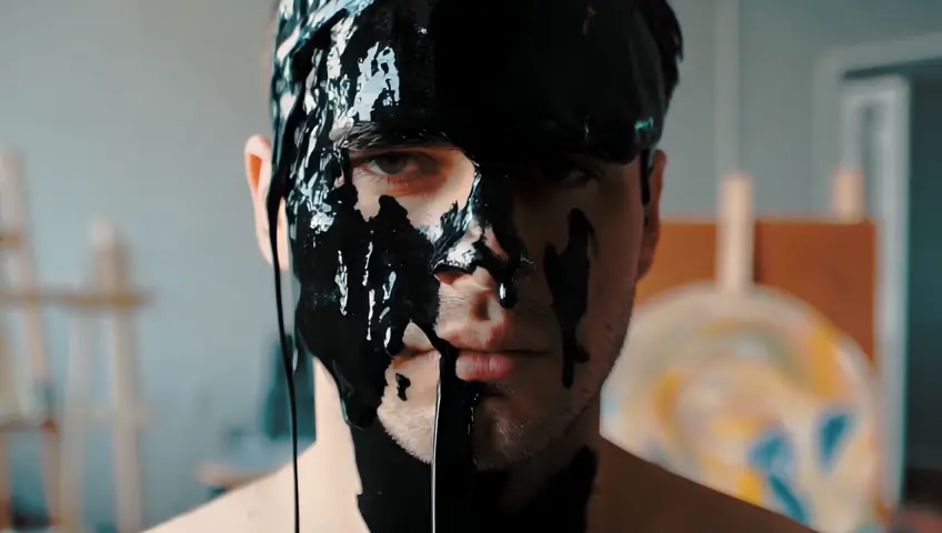 Abundant black paint falls on the man's head