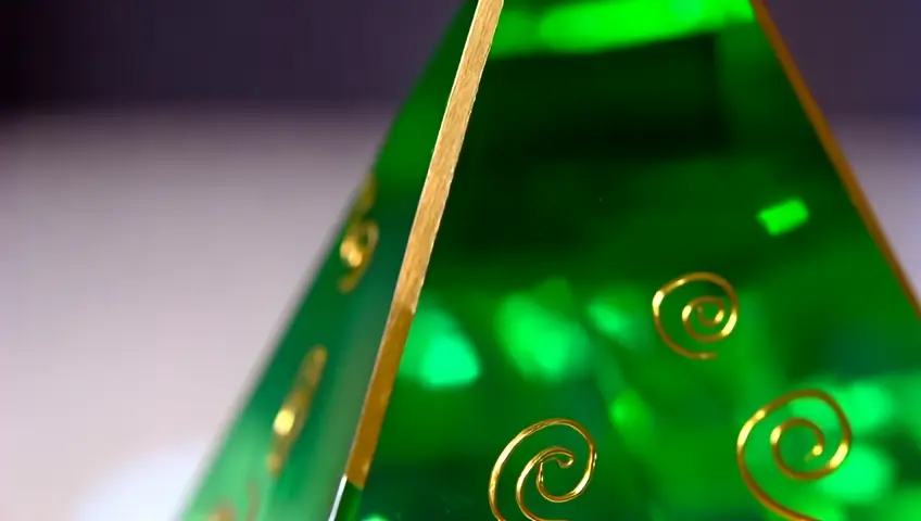 Pirámide de cristal de color verde esmeralda con espirales dorados