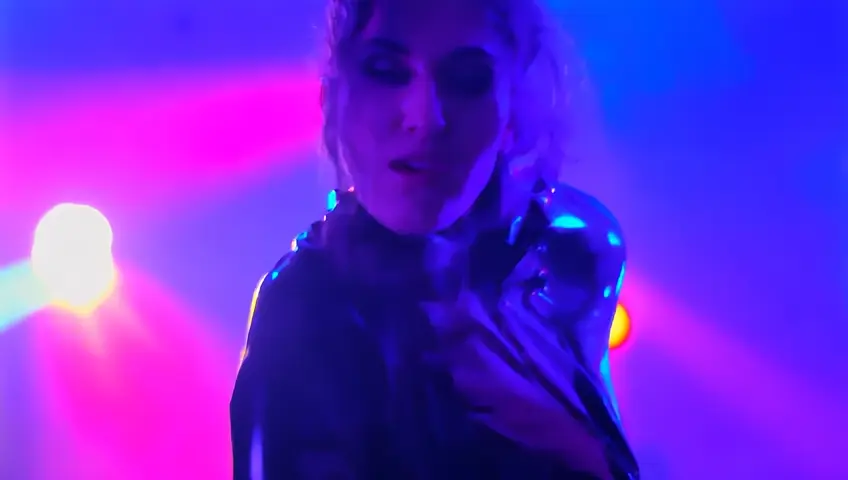 very beautiful 25 year old girl dressed in a tight black latex kit dancing at a rave