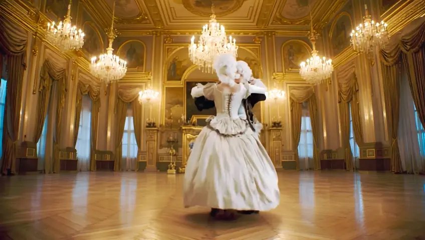French couple; a young man and a woman from the XVIII century and white wigs dancing minuet in a big old palace