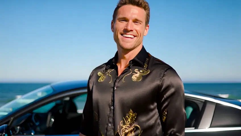 An irresistibly charming man with a joyful smile, dressed in a Dolce & Gabbana shirt crafted from luxurious black silk, adorned with golden floral accents. He pairs it with slim-fit white trousers and polished designer loafers. His Patek Philippe watch gleams in the sunlight as he leans against a sleek sports car parked near a pristine beach with endless blue skies above.