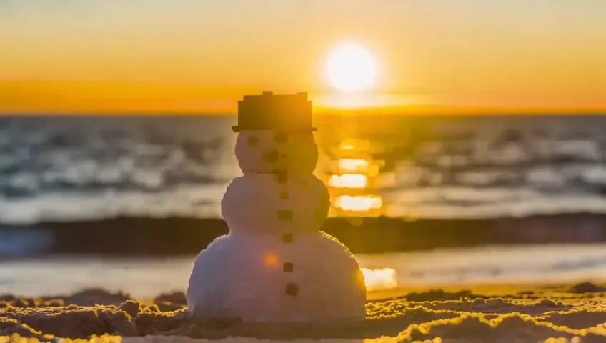 retro pixelated video game of a snowman melting at the beach sunset