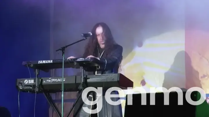 a man standing at a keyboard on a stage