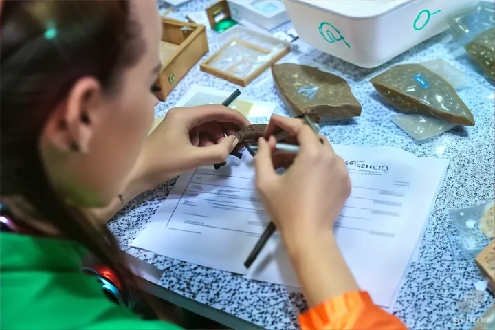 a woman is working on a piece of rock