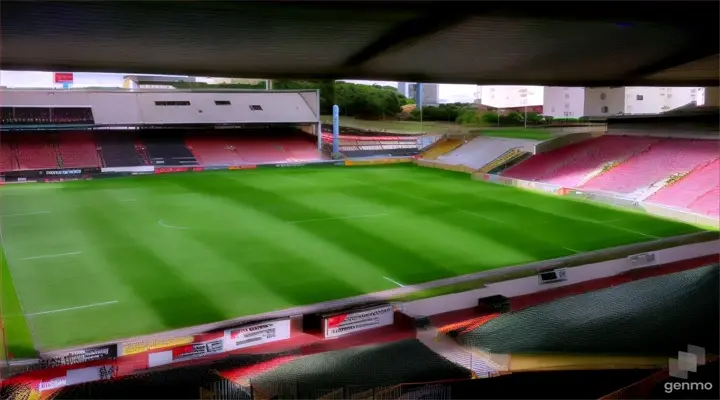 an empty soccer stadium with a green field