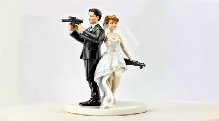 a figurine of a bride and groom holding a gun