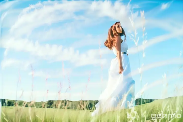 a woman in a white dress standing in a field