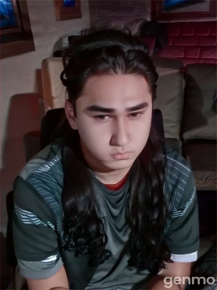 a boy with long hair sitting on a couch