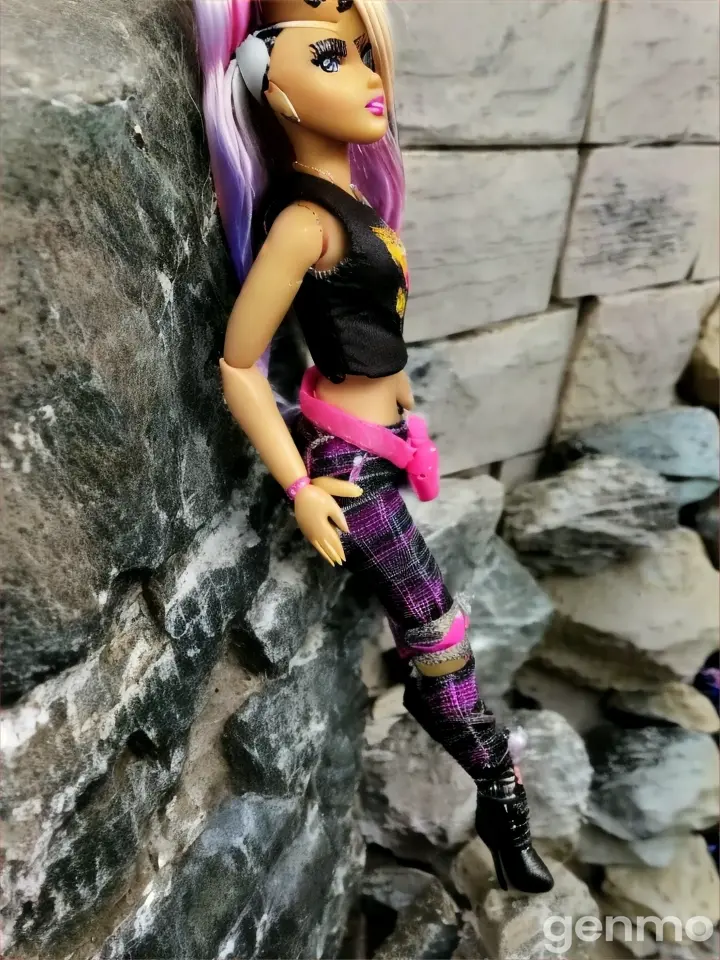 a barbie doll is posed on a rock