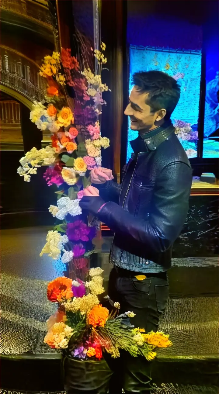 a 25 year old man in a black leather moto racer jacket and black
jeans takes a flower and smiles on an afternoon in a Roman Coliseum , advertising style
