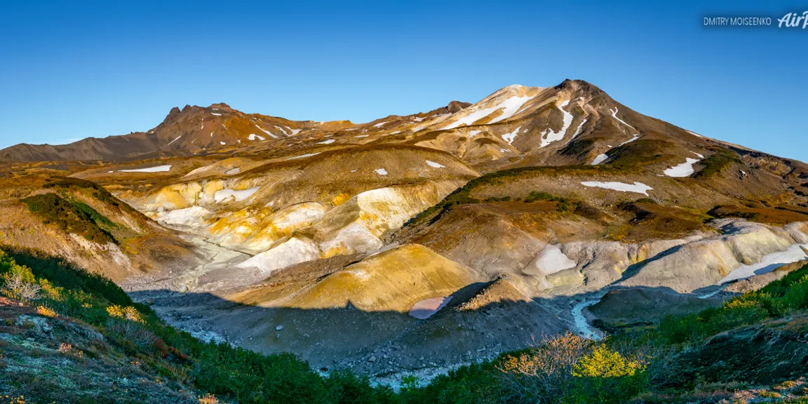 a view of a mountain range with a blue sky in the background