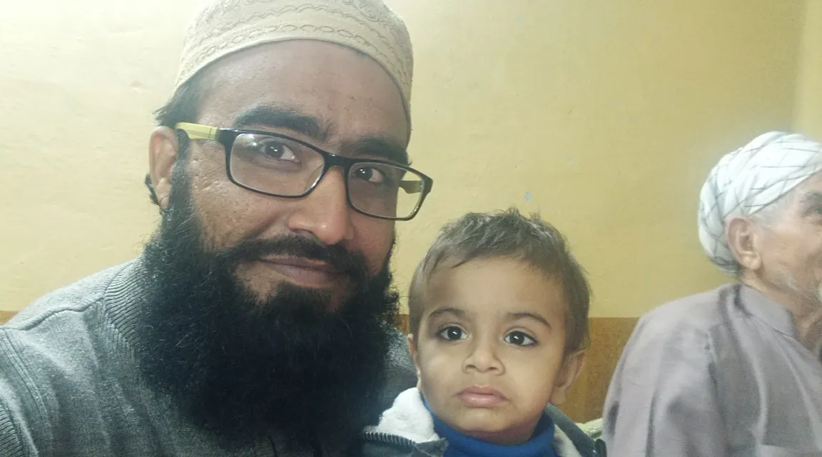 a man with a beard standing next to a little boy