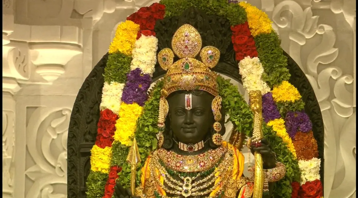 a statue of a hindu god with flowers around it