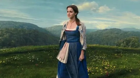 a woman in a blue dress standing in a field