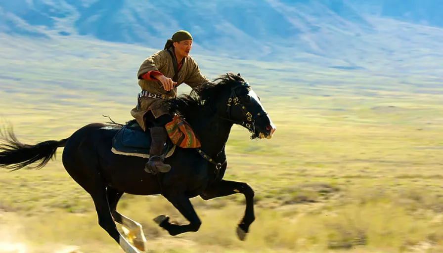 a man riding on the back of a black horse