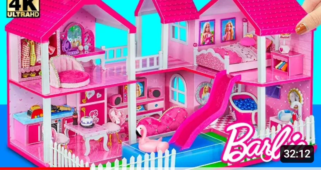 A pink doll house with a slide in the middle, situated in a wintry wonderland with snowflakes, icicles, and frosted trees