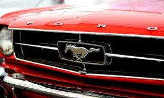 a close up of the front of a red mustang