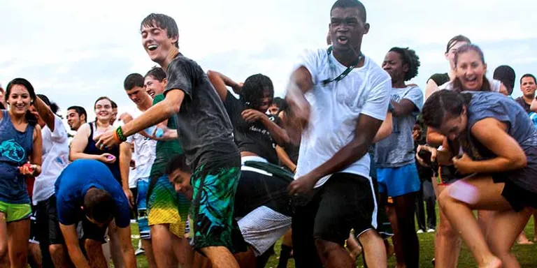 a group of young people playing a game of frisbee