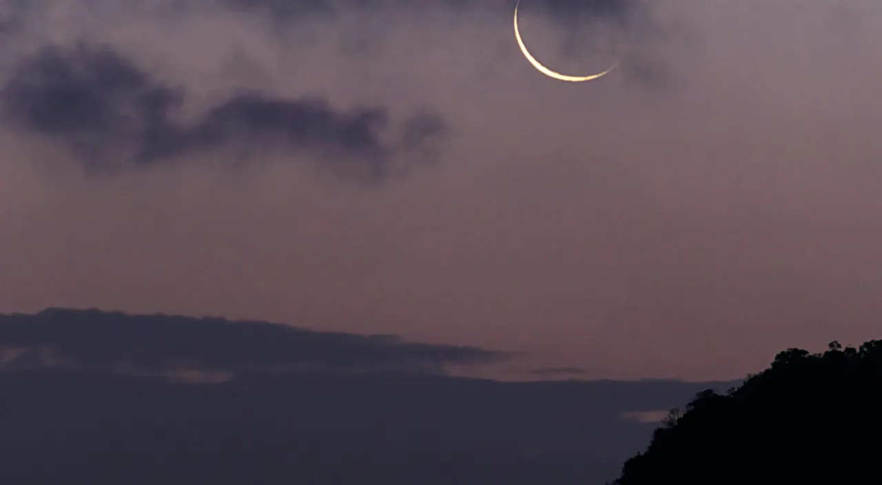 a crescent is seen in the night sky