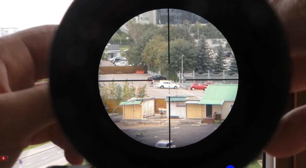 a person holding a camera lens up to a view of a parking lot