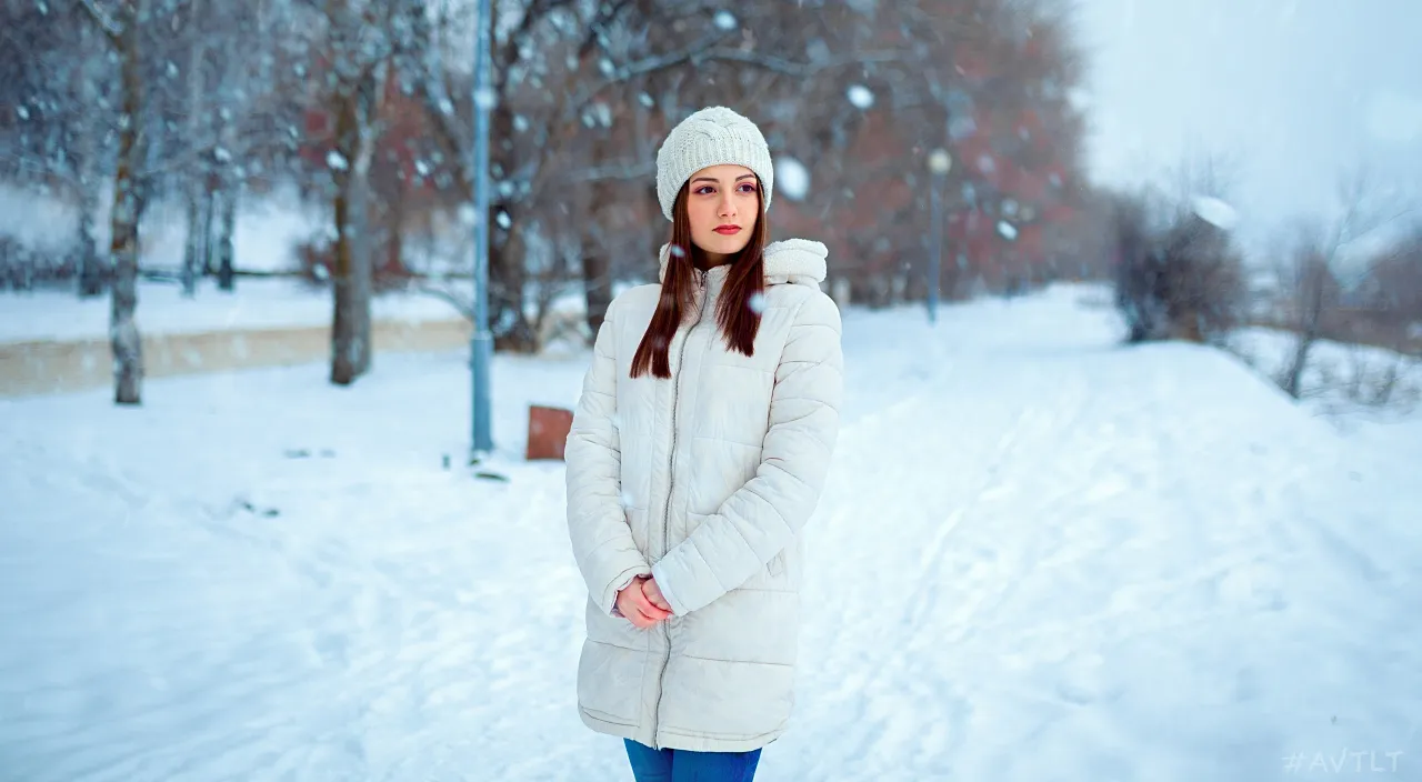 a woman standing in the snow in a park