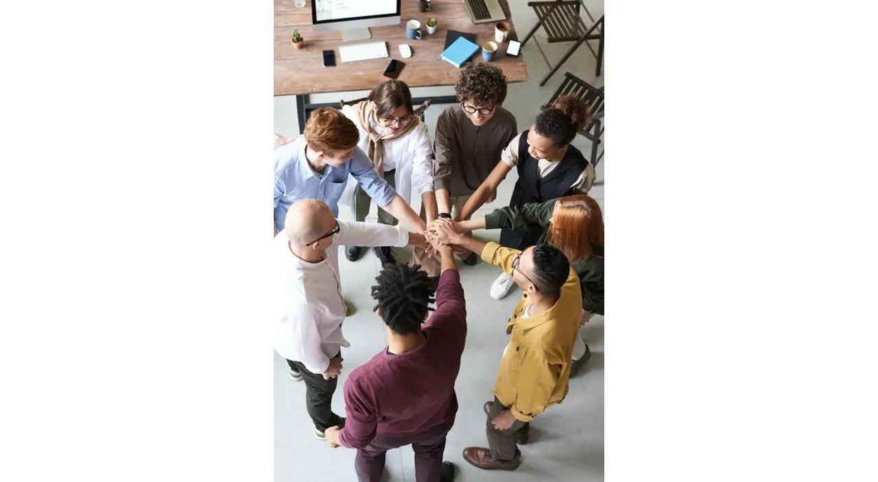 a group of people putting their hands together