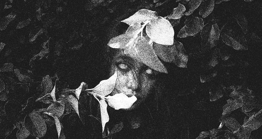 a black and white photo of a woman's face with a flower in her