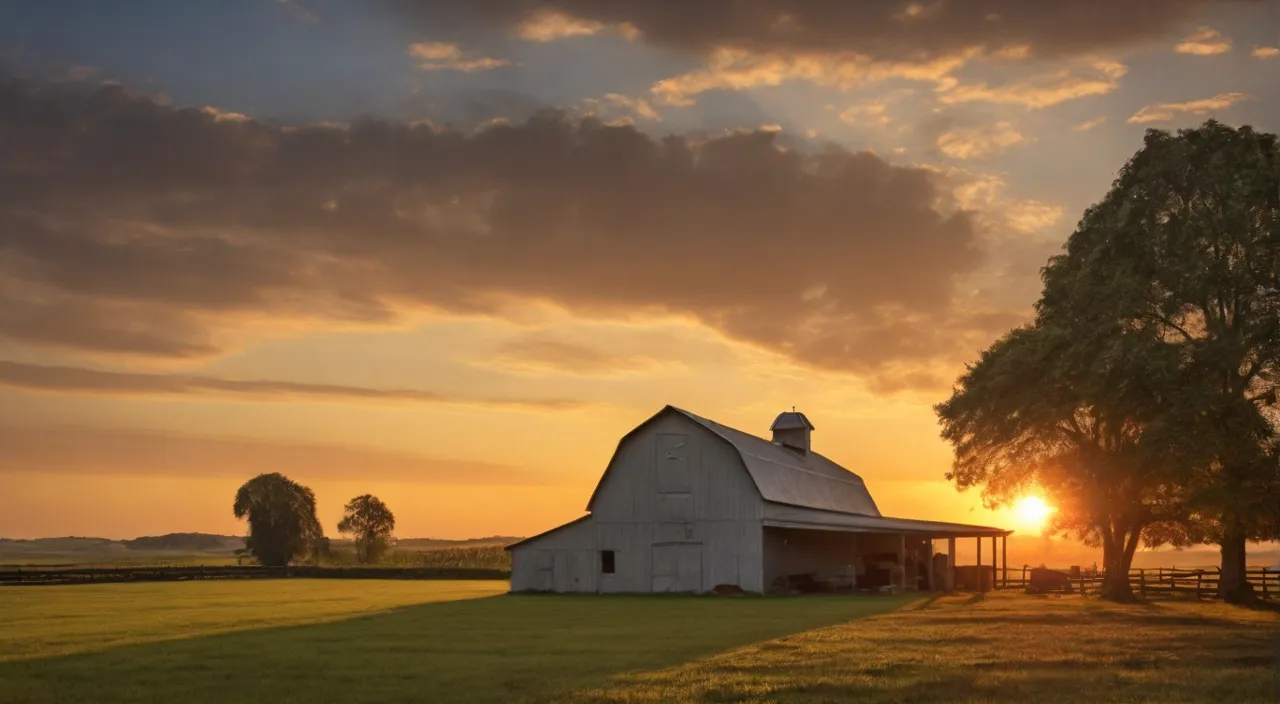 a large white barn sitting on top of a lush green field