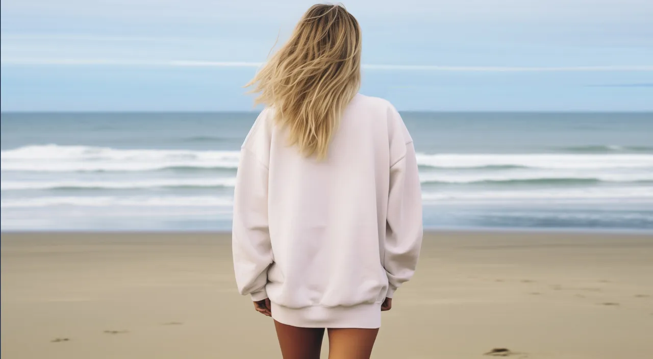 a woman standing on a beach looking at the ocean