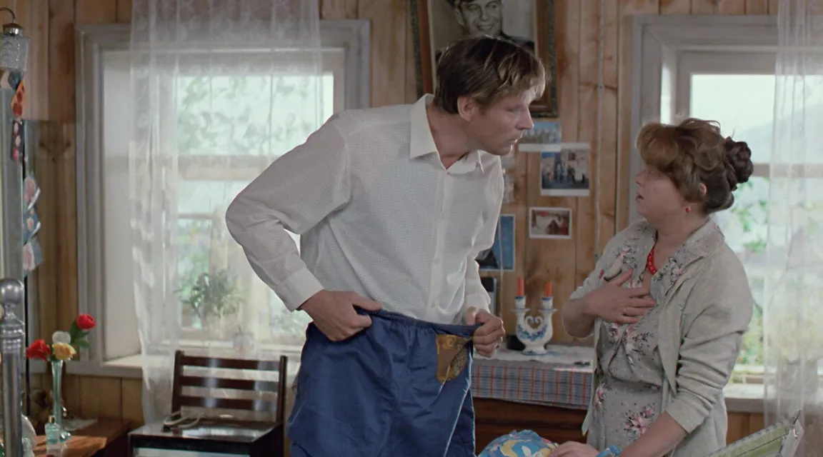 a man standing next to a woman in a living room