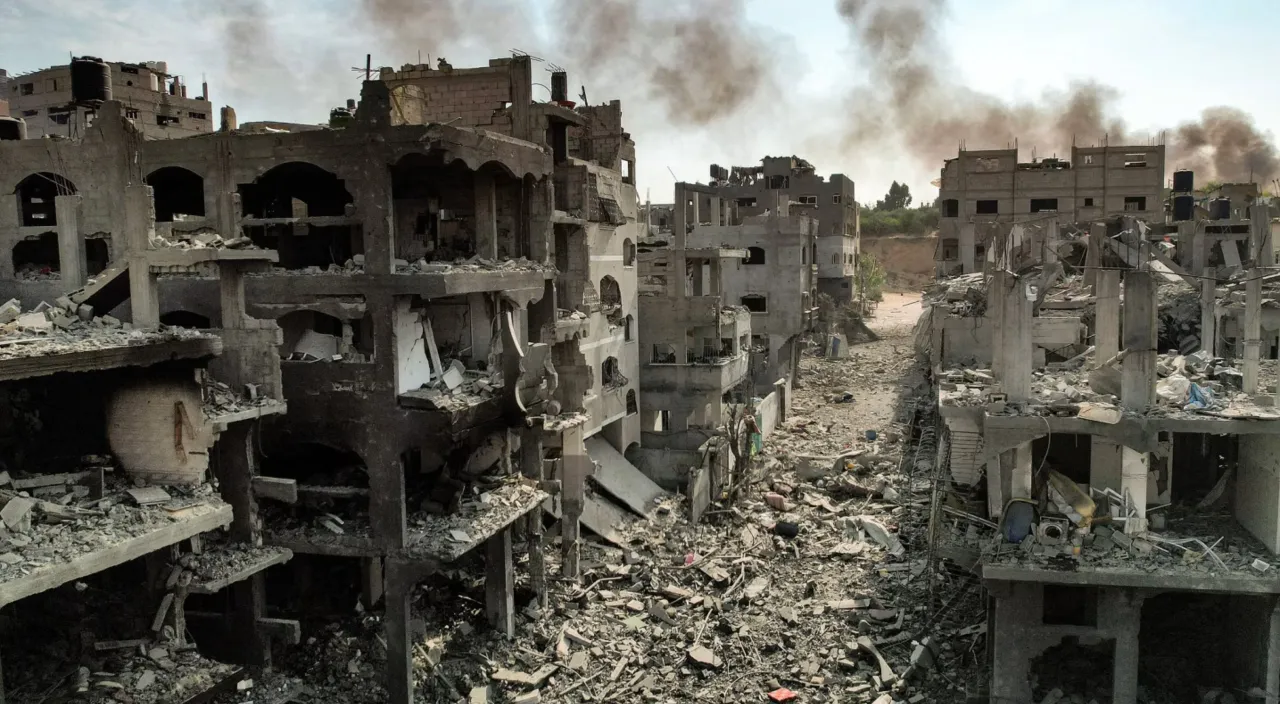 a destroyed building with smoke billowing out of it