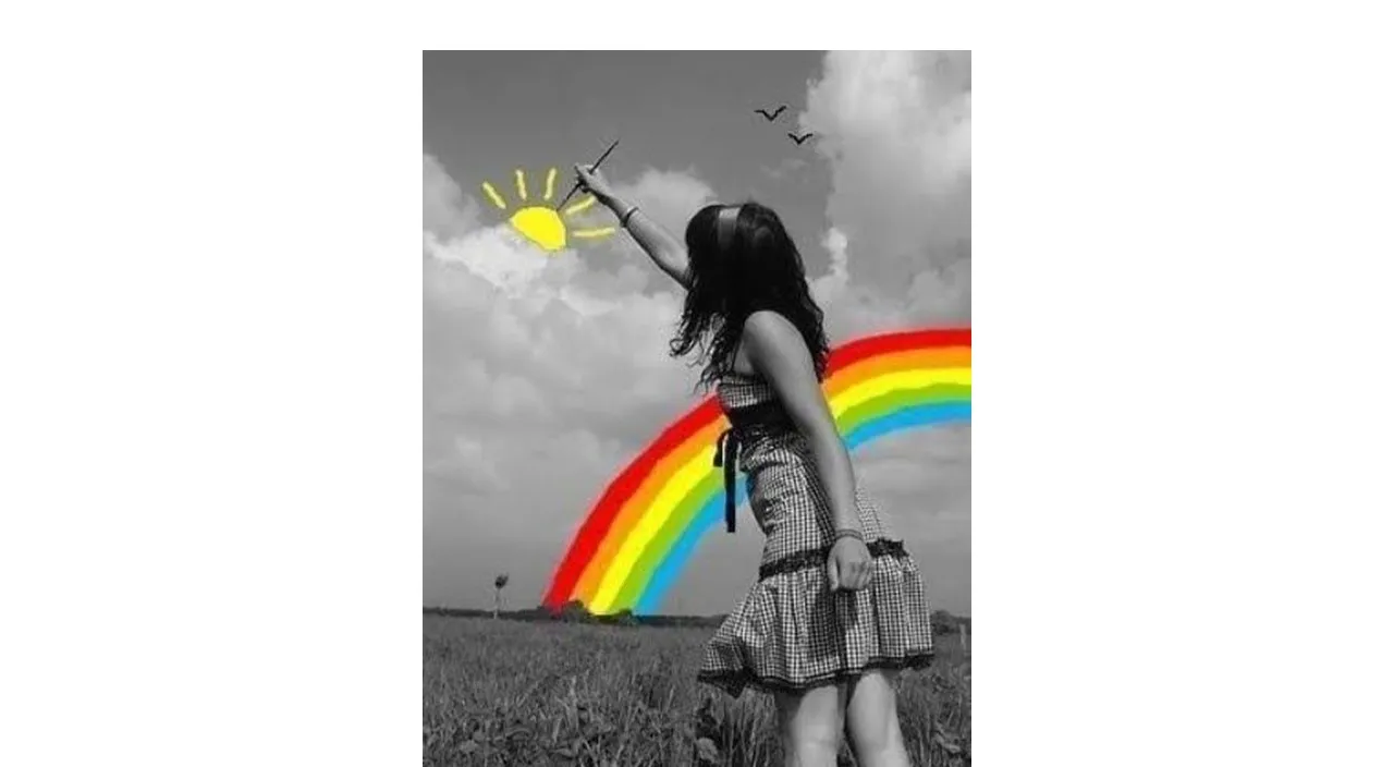 a girl flying a kite in a field with a rainbow in the background