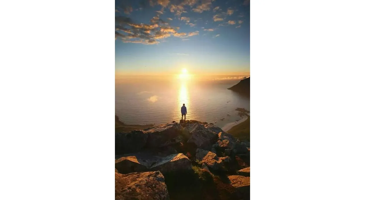 a person standing on top of a mountain overlooking the ocean