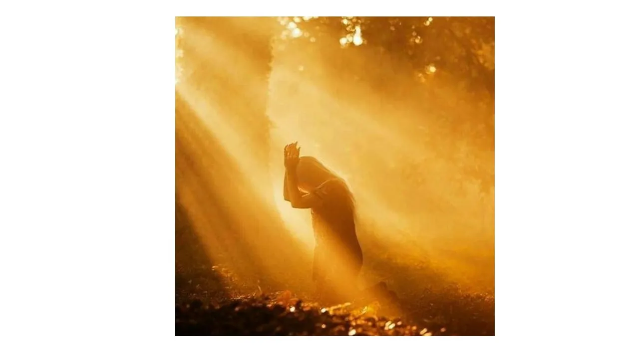 a woman praying in the middle of a forest