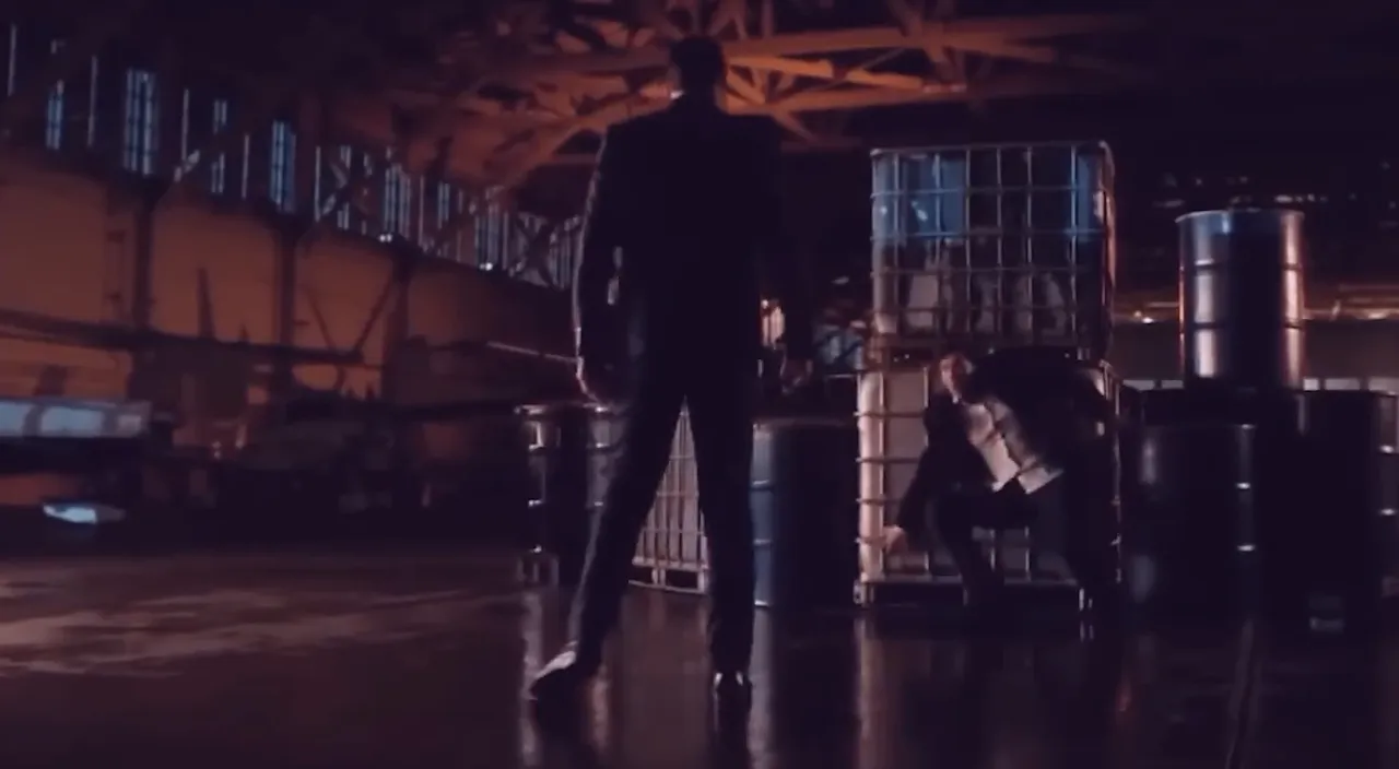 a demon in a suit standing in a warehouse and other man scary 