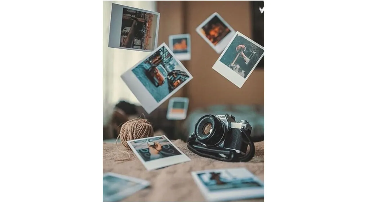 a camera sitting on top of a bed next to pictures