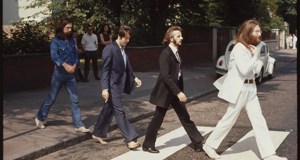 The image of the Abbey Road crossing with the image of the Four Beatles crossing with the same outfit as in the original photograph from the 60s or 70s all in cartoon mode in Pixar style in 3d Only four beatles Compare real and translapolar image, clothes the same as in the image more style Pixar studios type Up the movie 