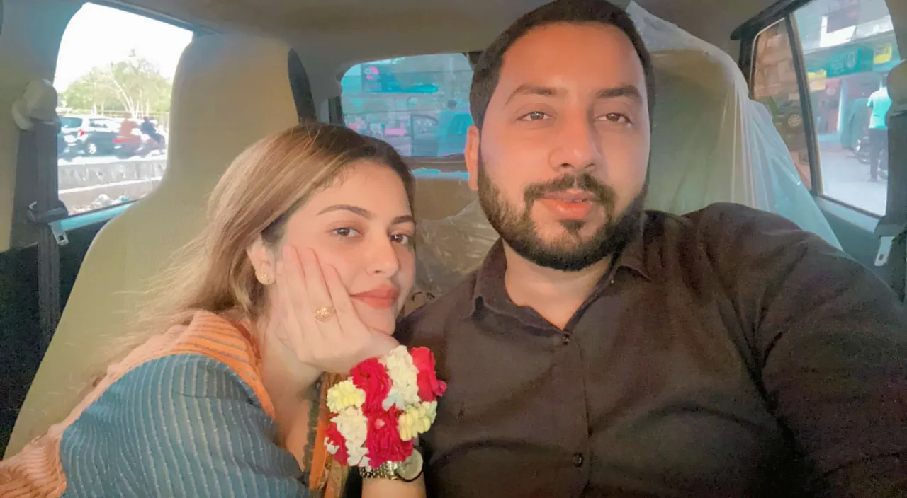 a man and woman sitting in the back of a car