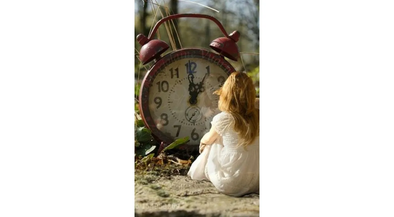 a woman sitting on the ground next to a clock