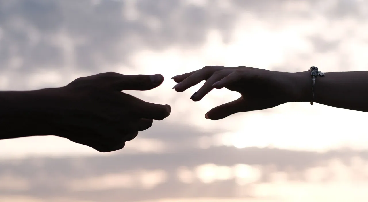 a couple of hands reaching out towards each other