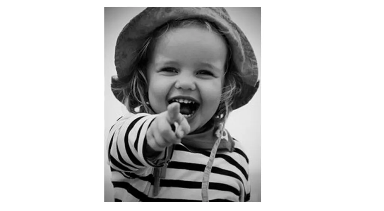 a black and white photo of a little girl wearing a hat