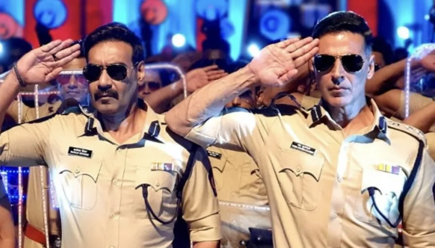 A close-up of a group of police officers' badges on a dark American flag with officers saluting in the background