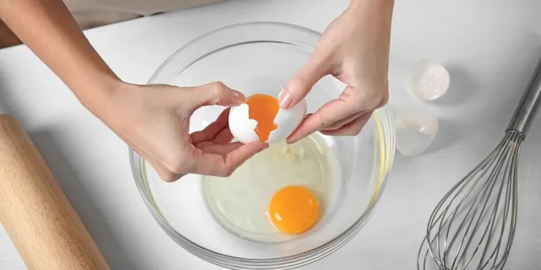 an AI woman is peeling an egg into a bowl