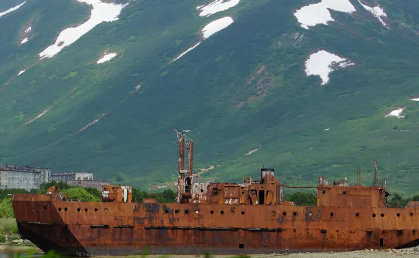 an old rusted ship sitting in a body of water