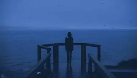 a person standing on a pier looking out at the ocean